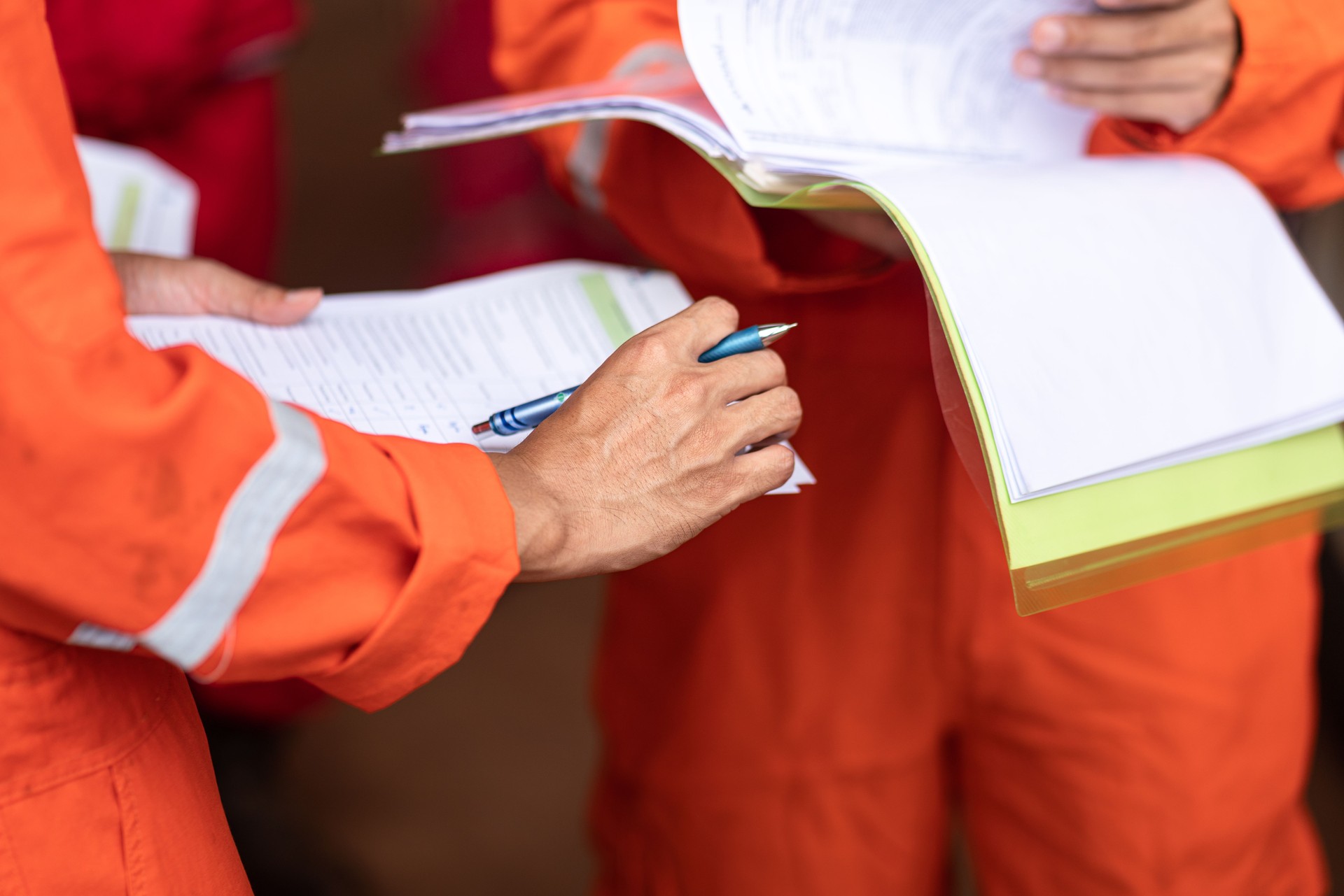 A supervisor is holding document paper during operational group meeting.